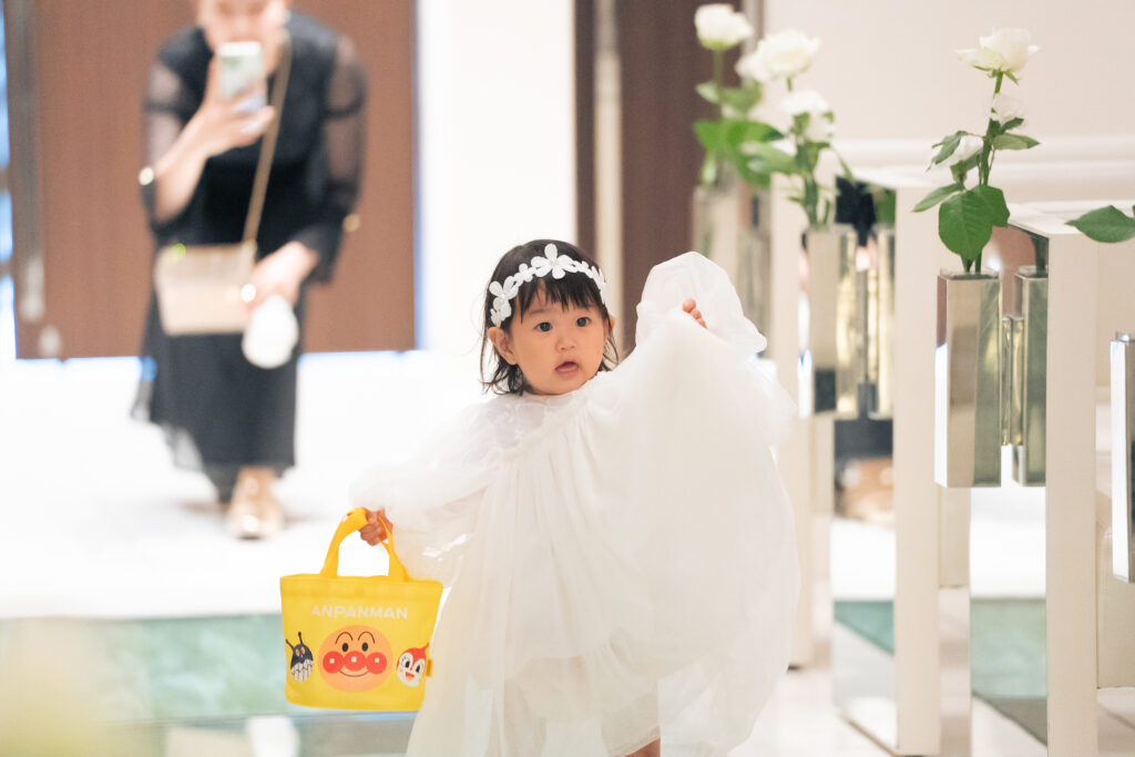 【名古屋市結婚式場ビアンカーラテラス】純白のドレスを纏い、チャペルでお手伝いをしてくれる小さなお子様ゲストの愛らしい姿。名古屋市にある市の結婚式場で叶う、ゲスト全員が笑顔になるアットホームな演出は、名古屋市内での挙式をより温かく思い出深いものにしてくれる、心温まるシャッターチャンスの一枚です。