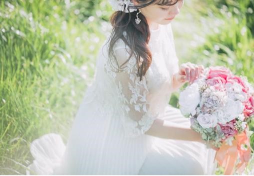 【名古屋市結婚式場ビアンカーラテラス】柔らかな光が降り注ぐ緑豊かなガーデンで、色鮮やかなピンクのブーケを手にする花嫁様。名古屋市にある市の喧騒を忘れる自然豊かなロケーションで、名古屋市内の喧騒から離れたようなナチュラルで美しいウェディングフォトを撮影できる魅力を詳細に描写しています。