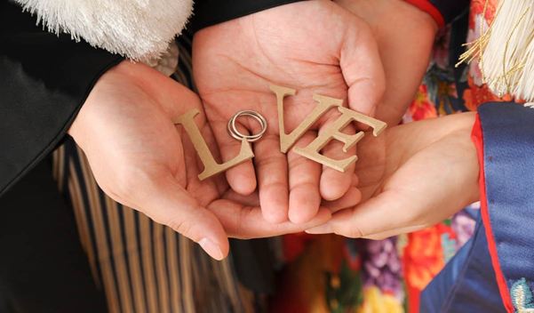 名古屋市の結婚式場ビアンカーラヒルサイドテラス。和装姿の新郎新婦がLOVEのオブジェと結婚指輪を手に乗せた、おしゃれで人気の高い前撮りフォト。