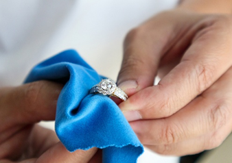 名古屋市結婚式場ビアンカーラテラスの結婚指輪を専用のクロスで優しくお手入れして汚れを落とす様子。