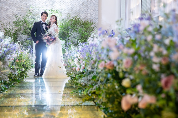 名古屋市結婚式場ビアンカーラヒルサイドテラス。新郎新婦に合わせた色鮮やかな花に囲まれてウェディングフォト。