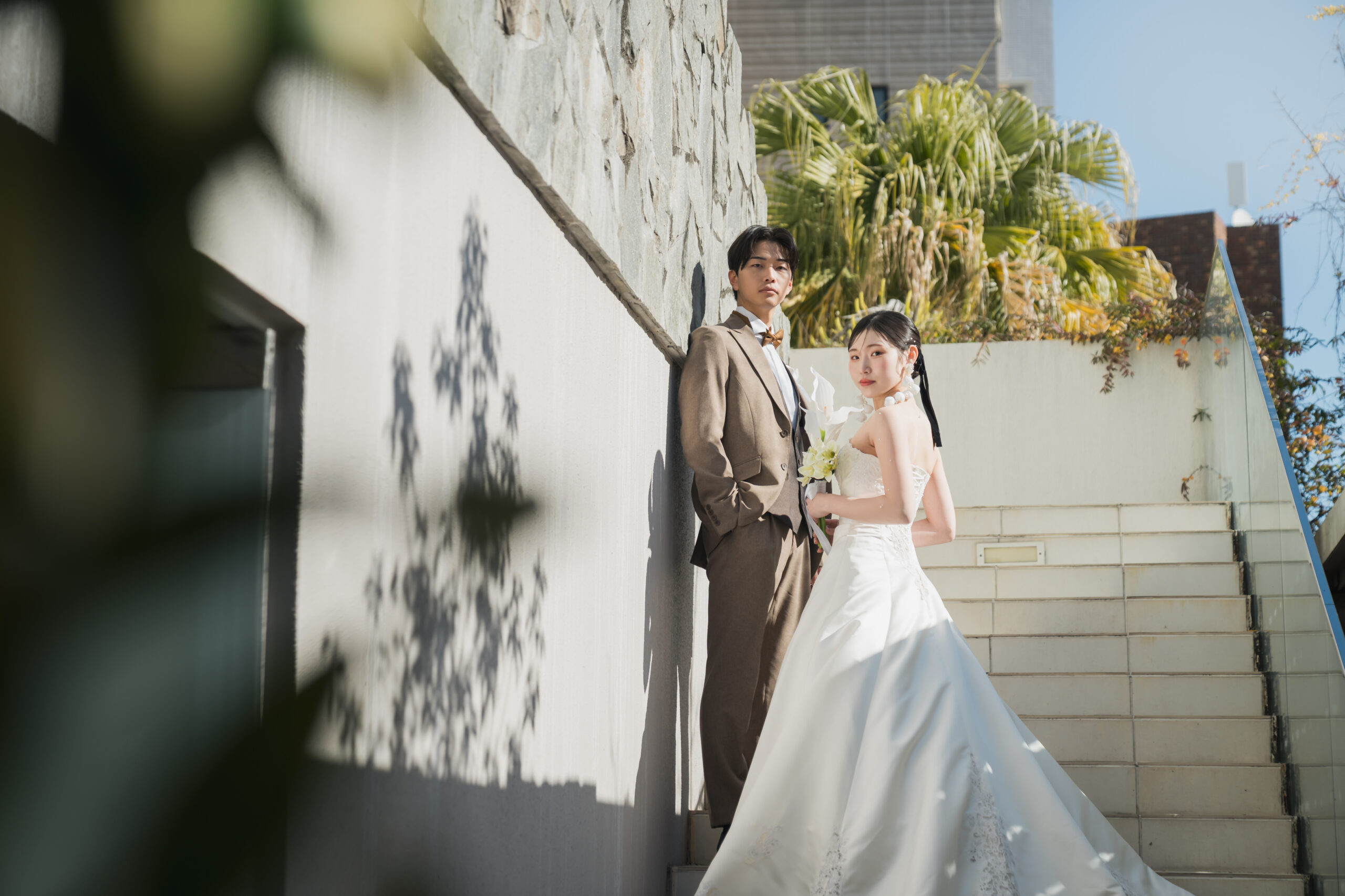 名古屋市の結婚式場ビアンカーラヒルサイドテラスの外階段で、強い日差しの下、スタイリッシュにポーズをとる新郎新婦