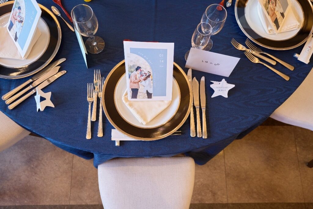 名古屋市の結婚式場ビアンカーラヒルサイドテラスのテーブルコーディネート。ネイビーのクロスに映える、新郎新婦の写真入りメニュー表と上品なカトラリー。